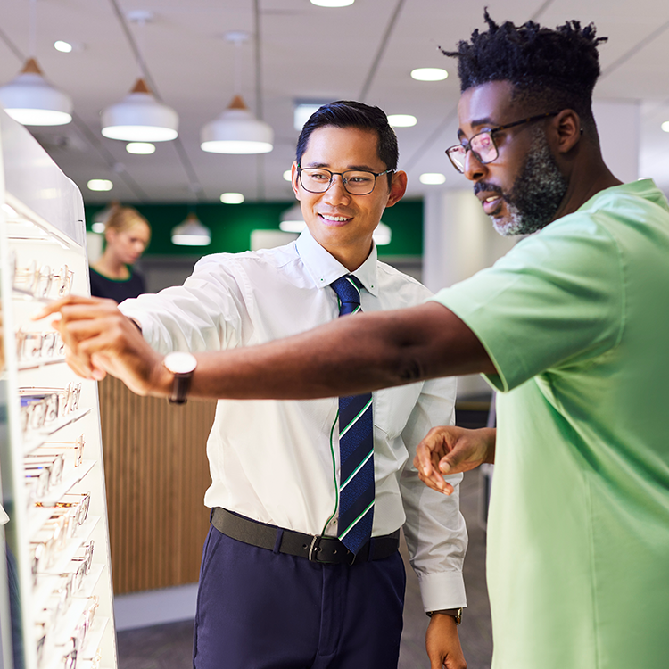 Specsavers salesman helping a customer with glasses options instore