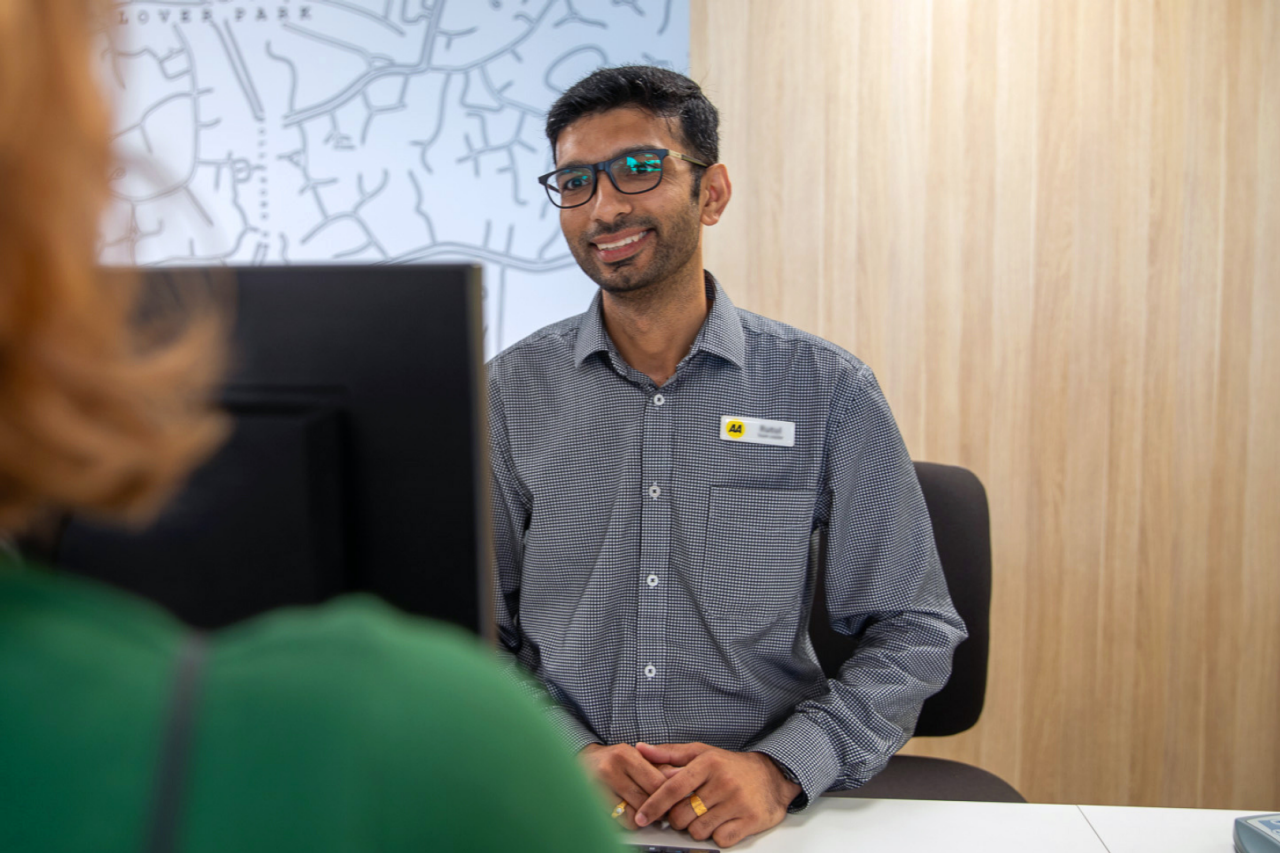 AA Centre worker helping a customer behind desk