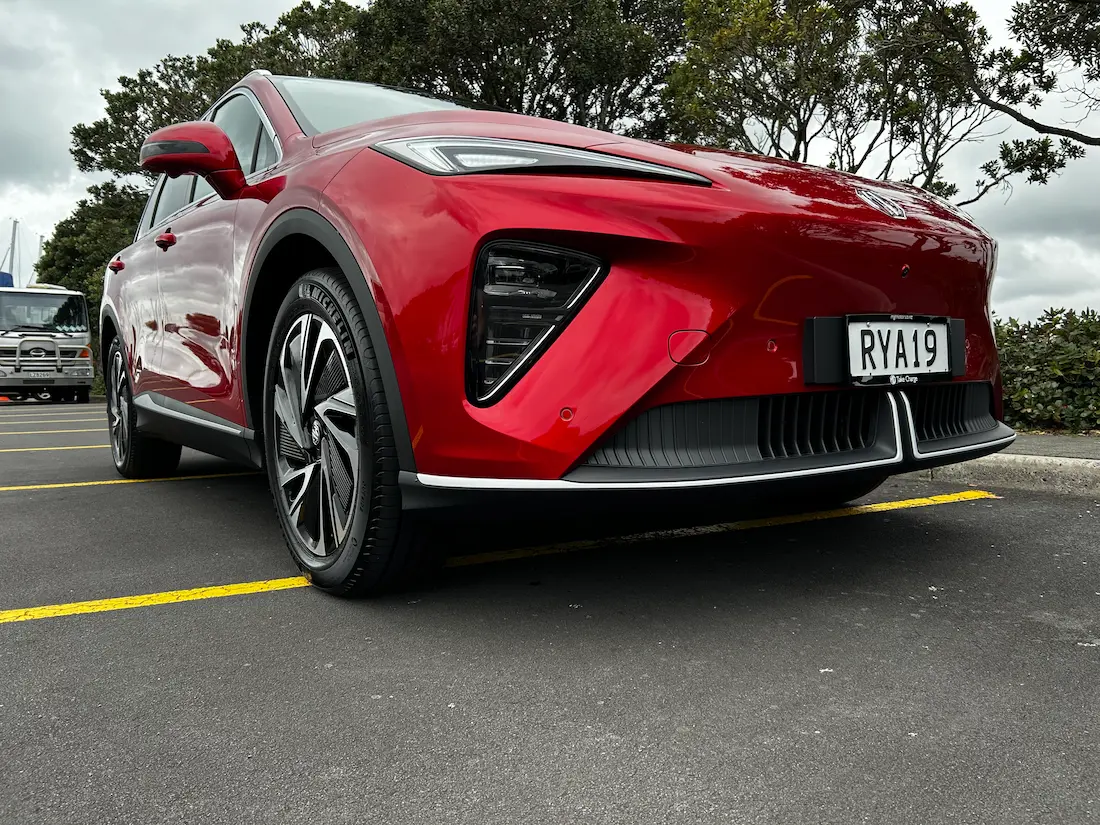 Low-angle front view of a red MG electric SUV in a car park.