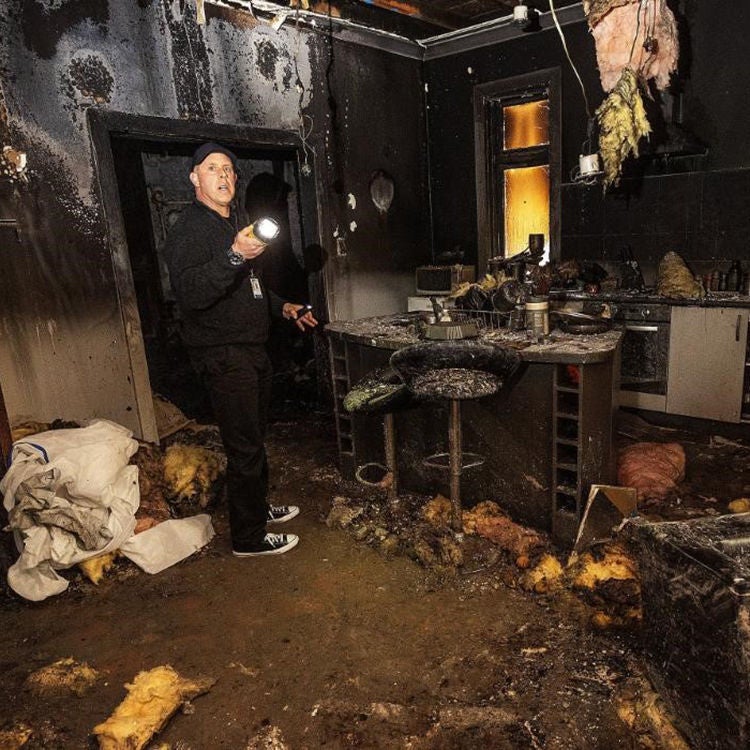 Mike Hart inspects the damage to his home after the house fire.