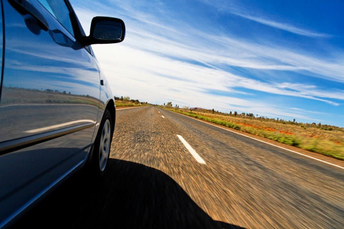 Close up of a car moving on a road at high speeds.