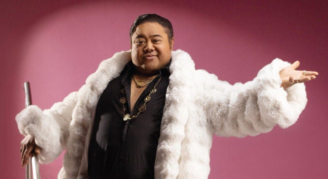 A man wearing a fluffy white coat, looking fabulous. 