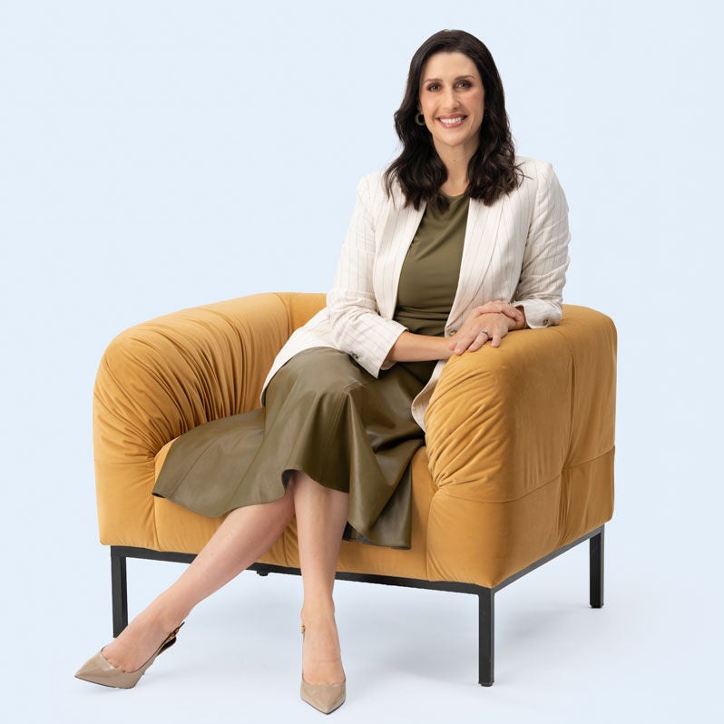 Nadine Higgins sitting on a yellow sofa