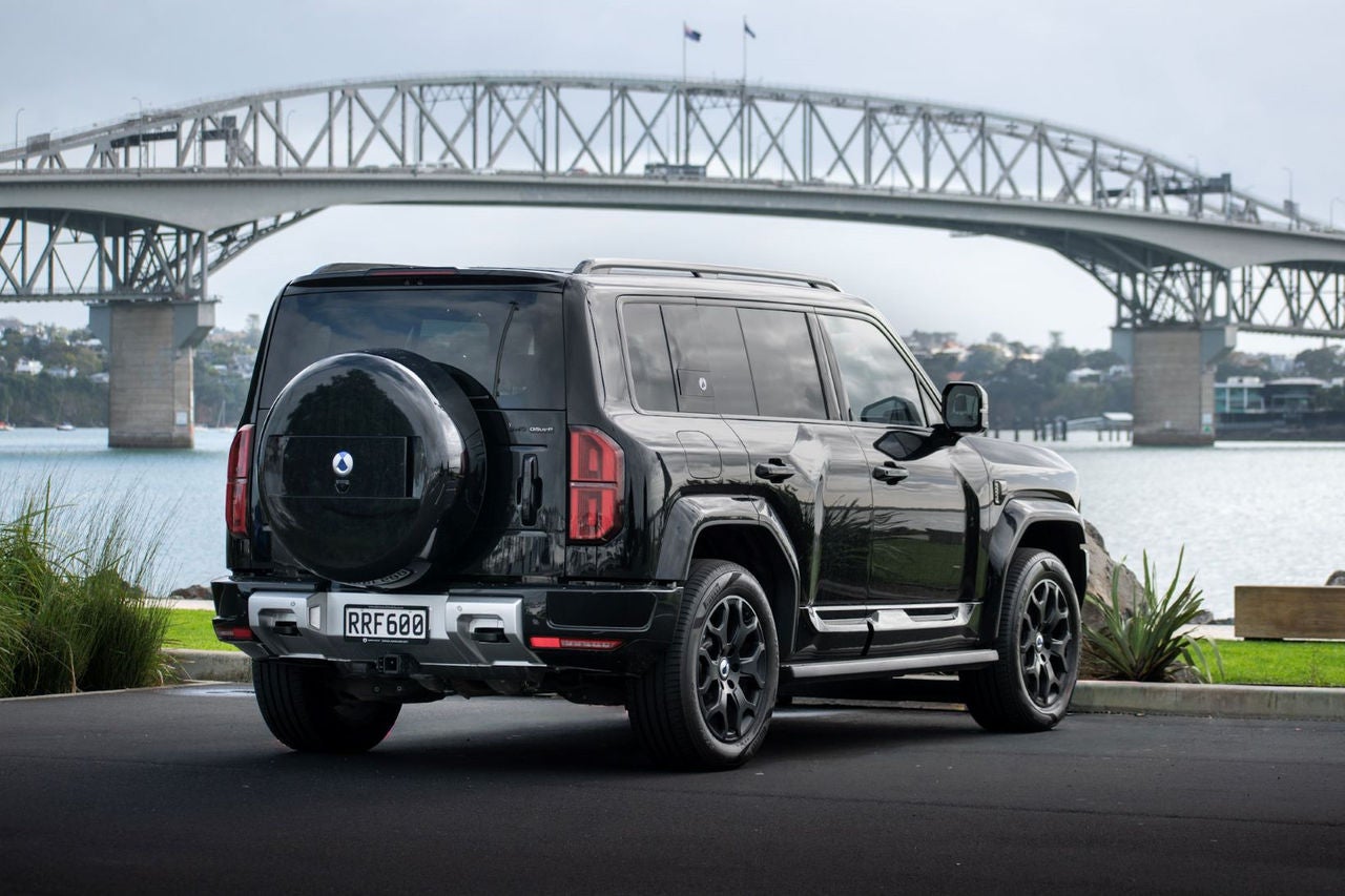 rear quarter view of black SUV in front of harbour