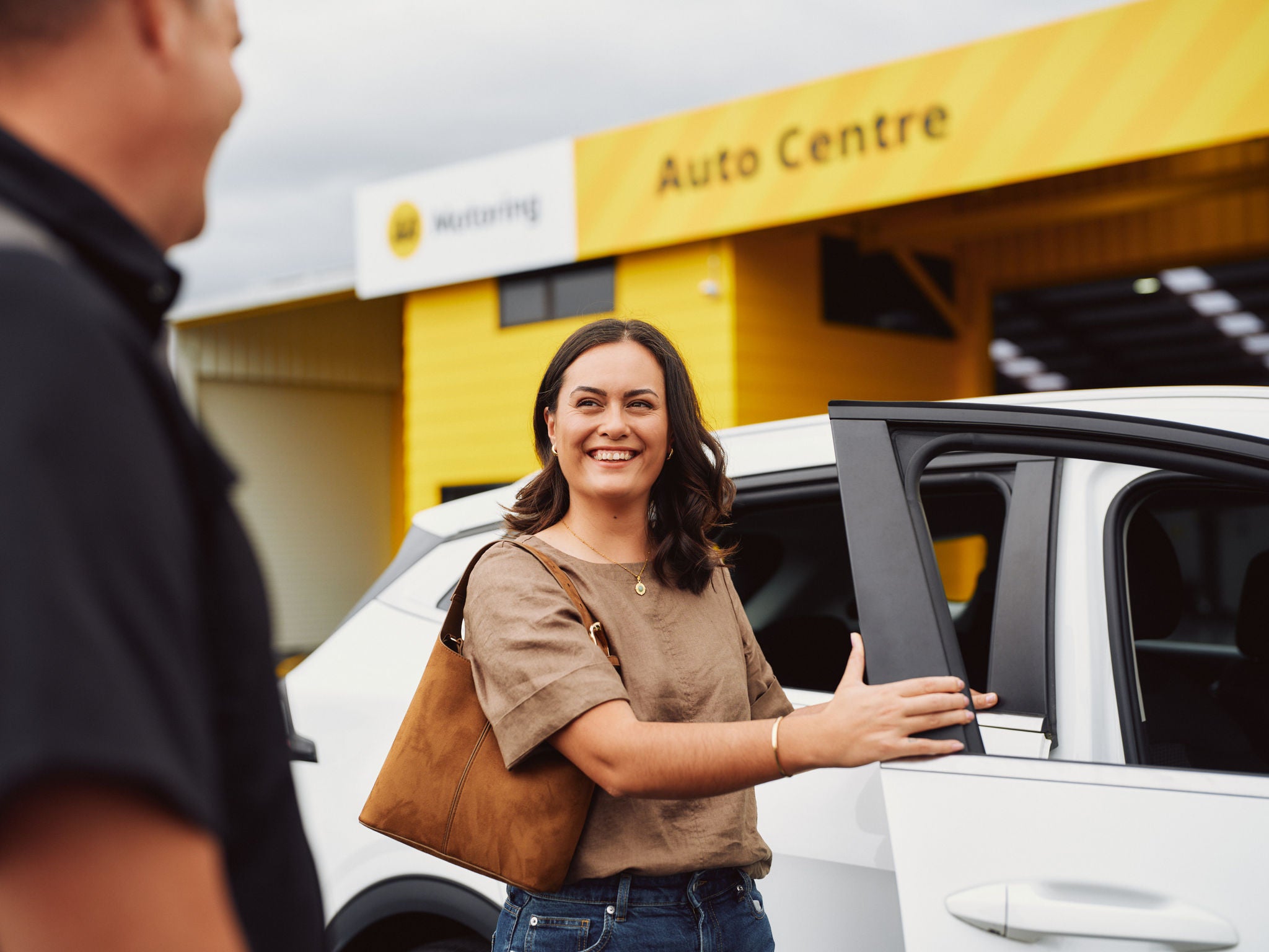 Woman stepping out of her car at an AA Auto Centre
