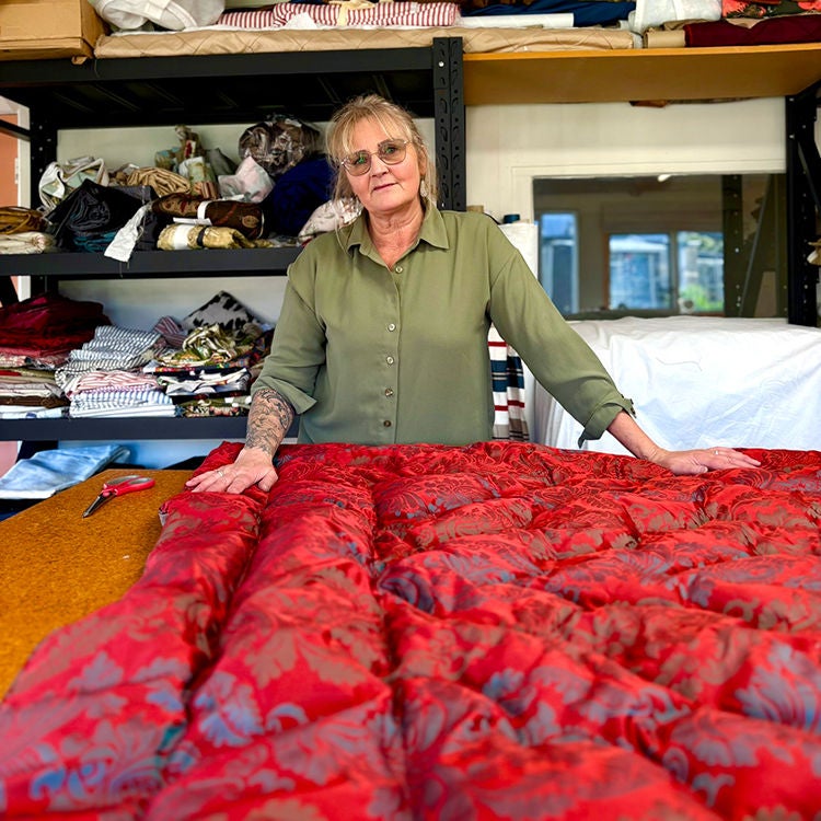 Anita Carter with one of her handmade eiderdowns. Photo by Jo Percival.