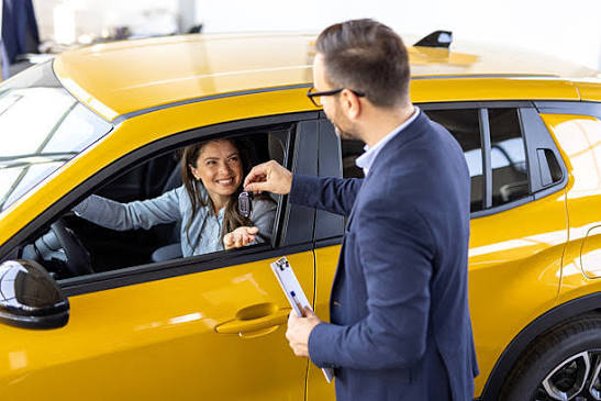 Customer being handed keys to rental vehicle from the driver seat