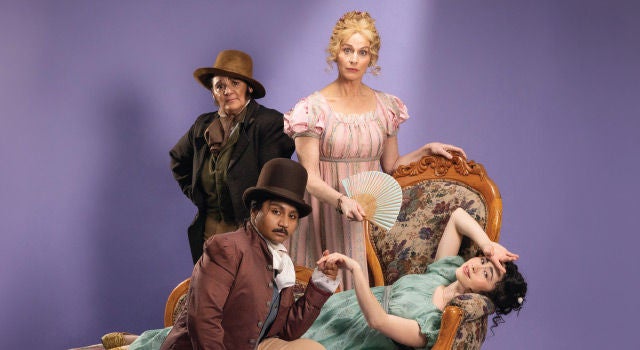 Four people lounging on a chaise lounge in regal attire. 