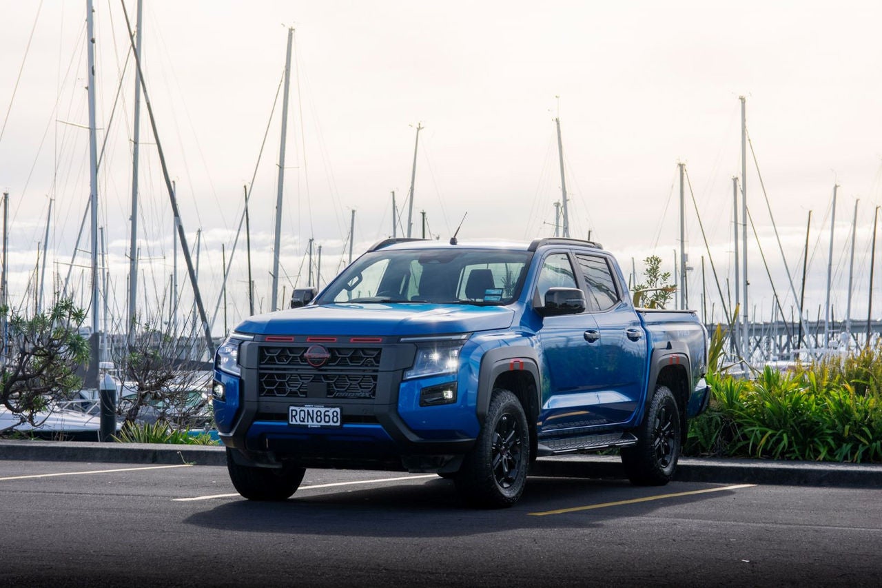 front quarter view of blue ute in front of marina