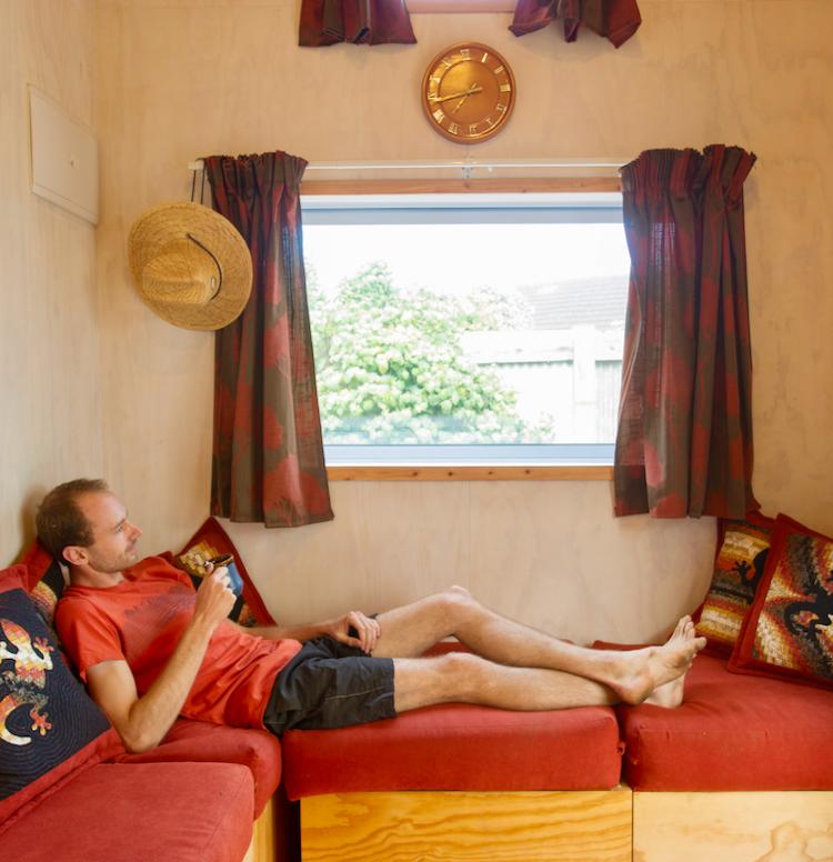 Matthew Lillis relaxing in his tiny house.