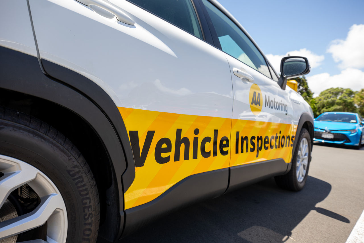Man inspecting the underneath of a vehicle