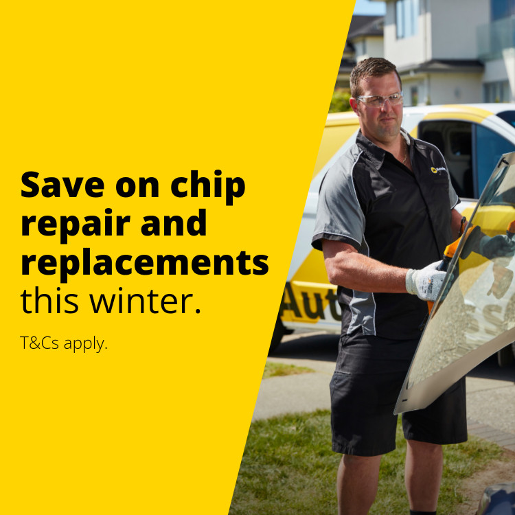 Copy reads: Save on chip repair and replacements this winter. T and Cs apply. Auto Glass technician in protective gear holding window replacement.