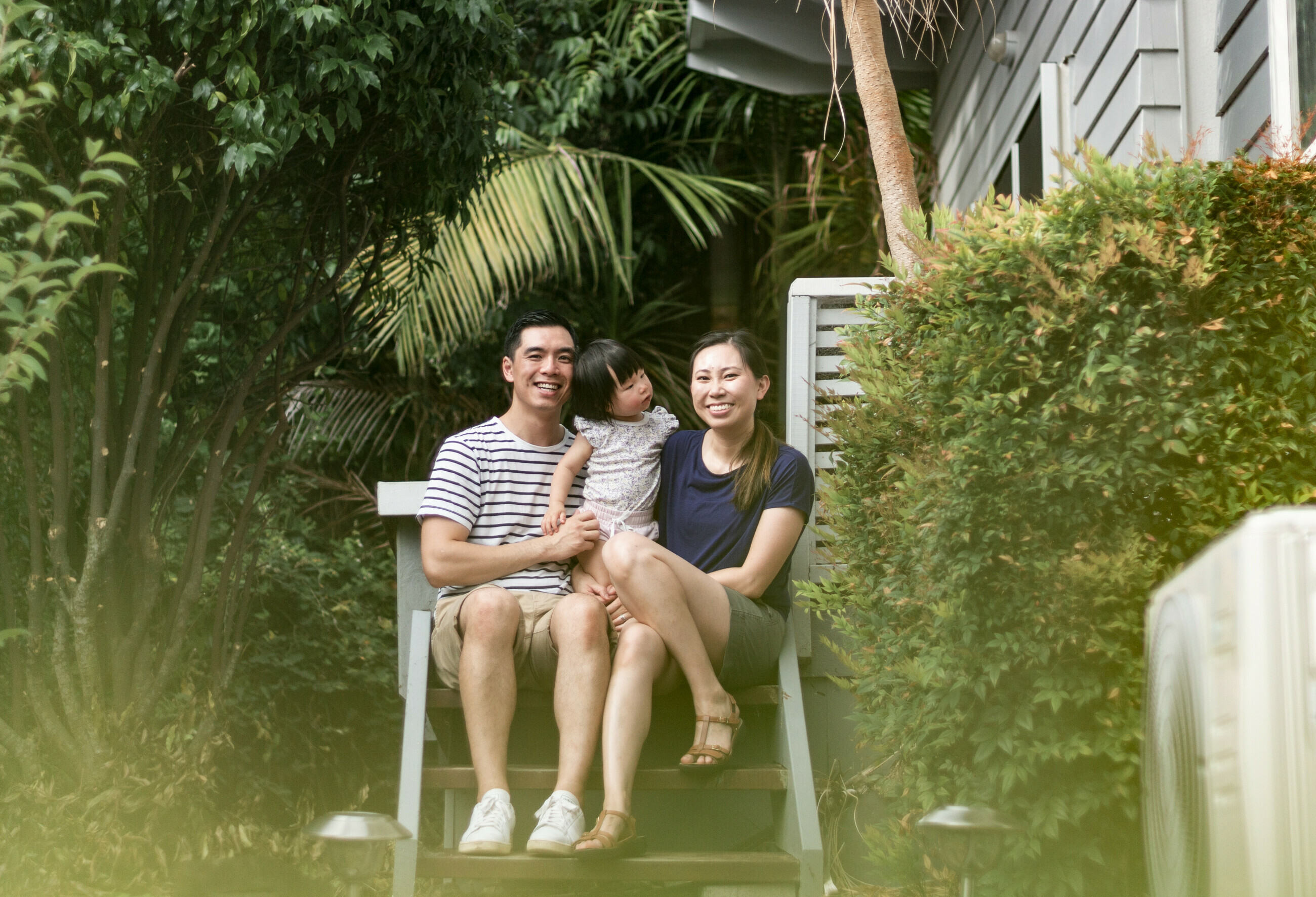 Young family smiling together outside their home