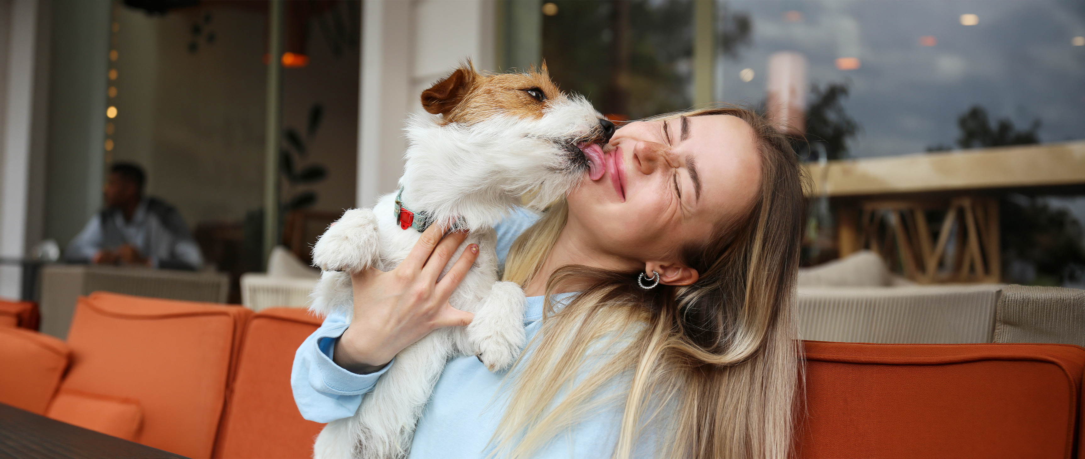 Woman smiling holding pet dog 
