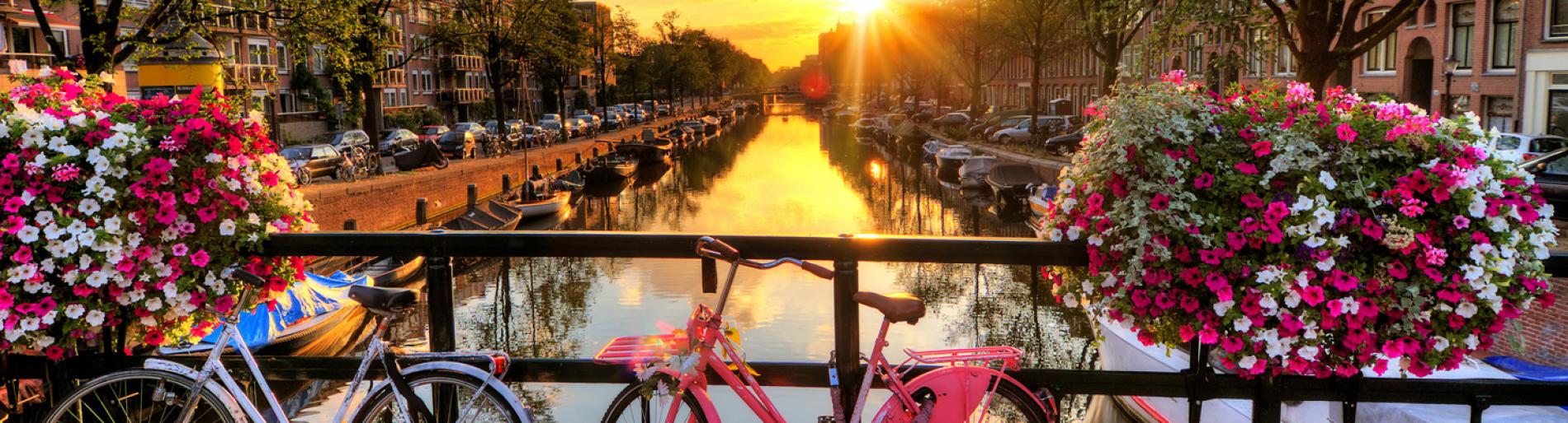 Bicycles on a canal bridge in Amsterdam at sunset
