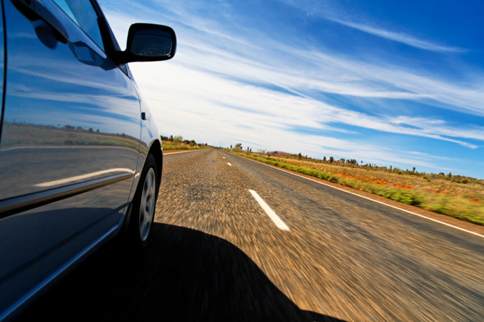 Close up of a car moving on a road at high speeds.