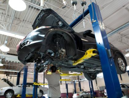 Lifted car at the mechanics with mechanic underneath
