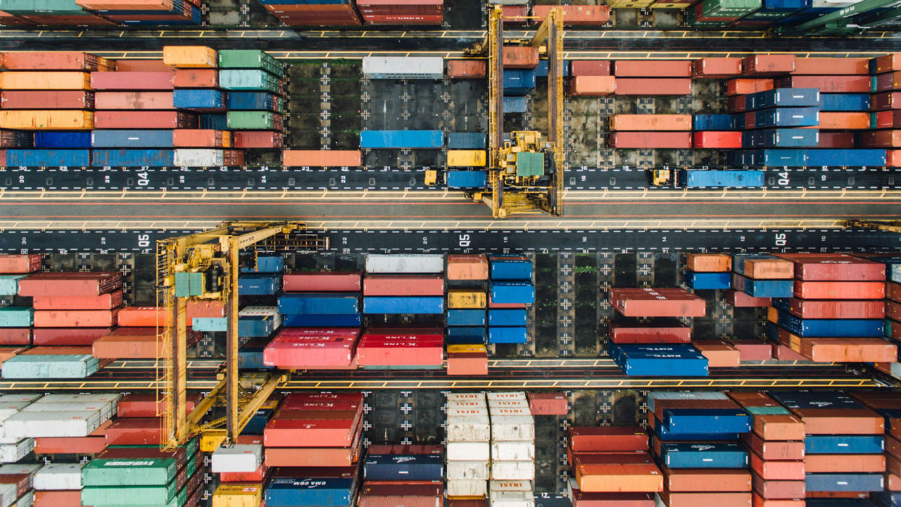 Aerial shot of a shipping yard stacked with containers.