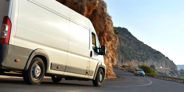 A business van driving along a coastal road