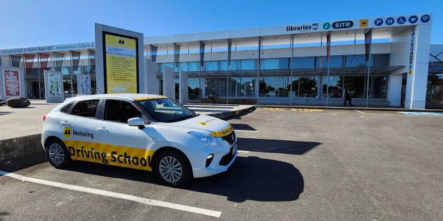 A parked AA Driving School car in a carpark