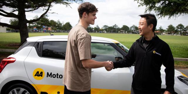 A young man shaking hands with an AA driving instructor
