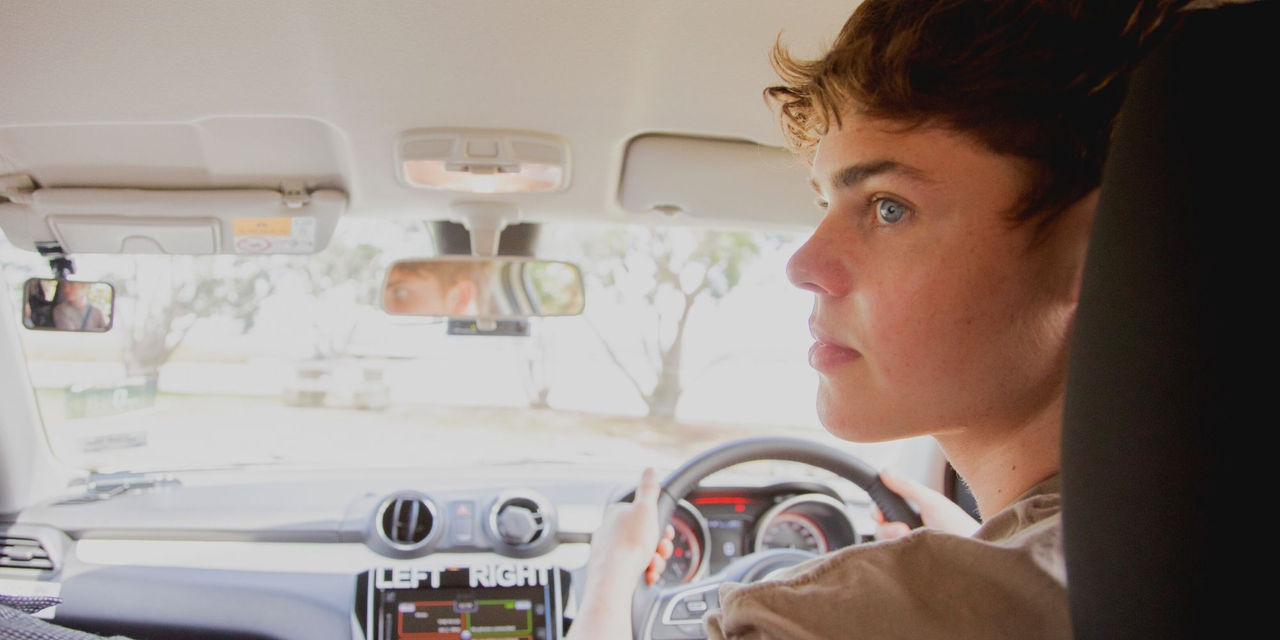 A student driver looking at the backseat