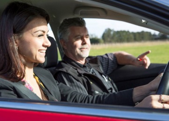 A woman driving with a man sitting in the passenger seat