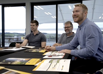 Three men around a table taking a defensive driving course.