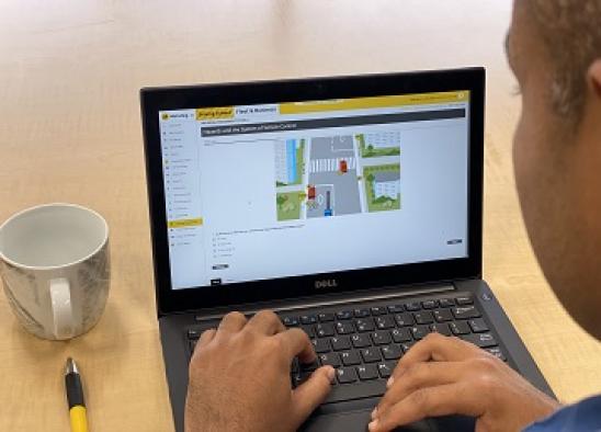 A man using his laptop to view AA website for online driver training modules