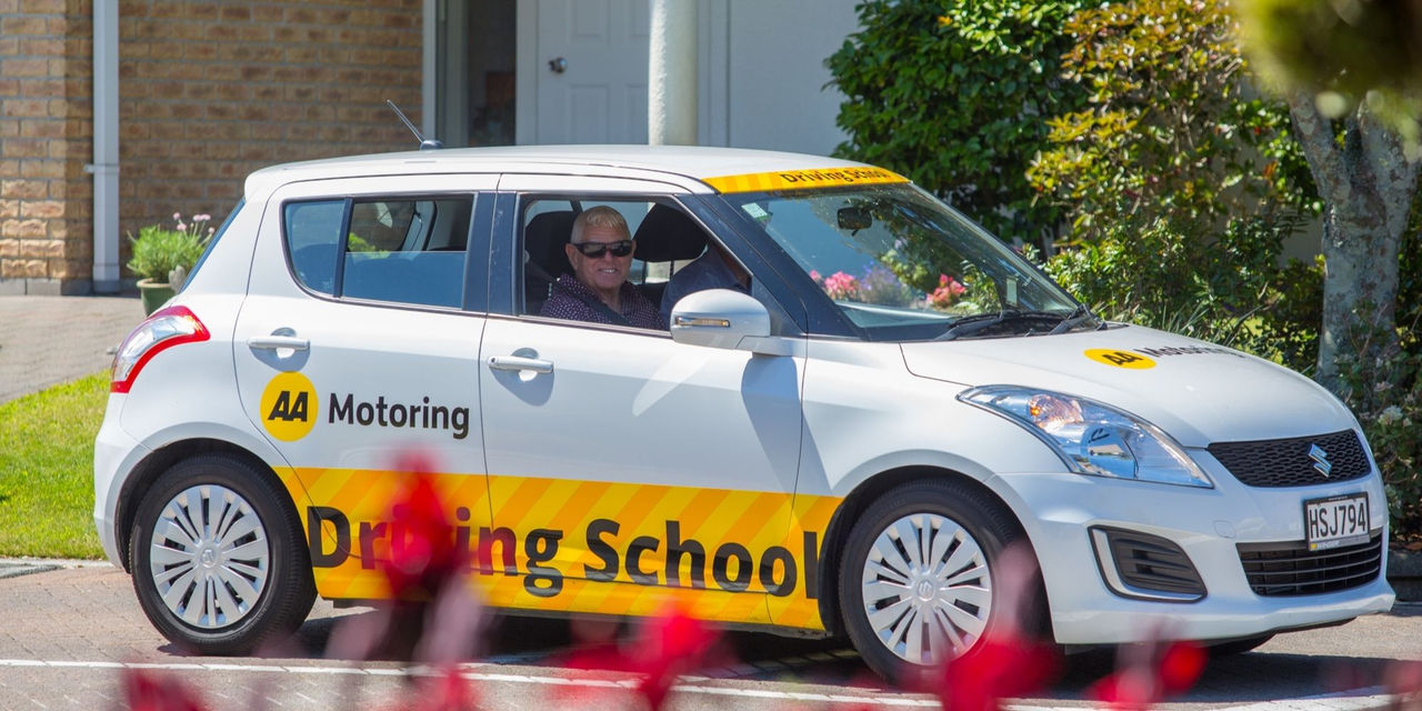 A man smiling while driving an AA Motoring Driving School car