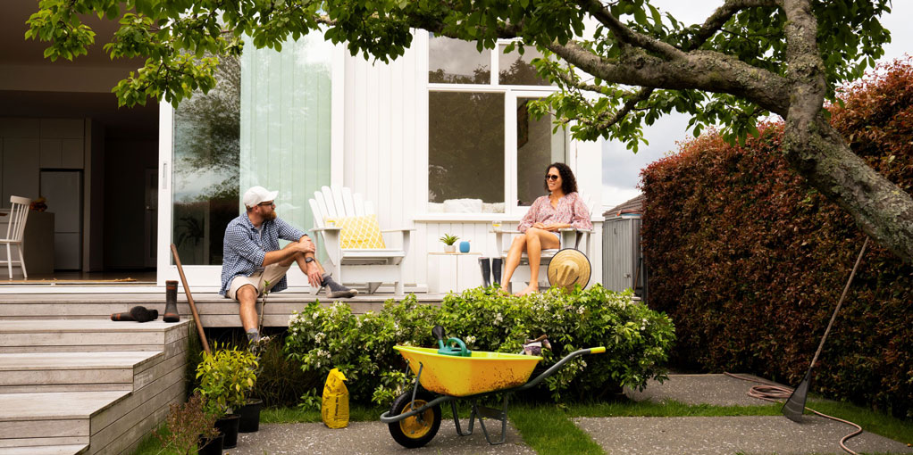 Couple taking a break from gardening to recline a deck
