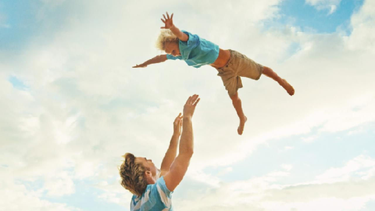 Dad throwing and catching his son in the air