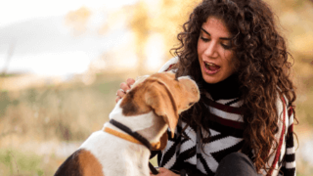 A woman patting her dog 