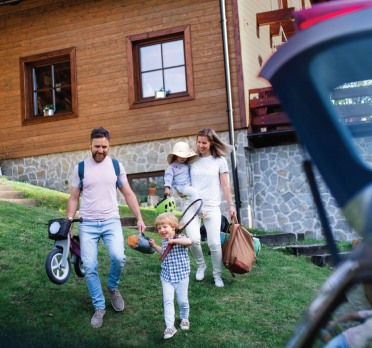 Family with young children gathering gear to load into a car