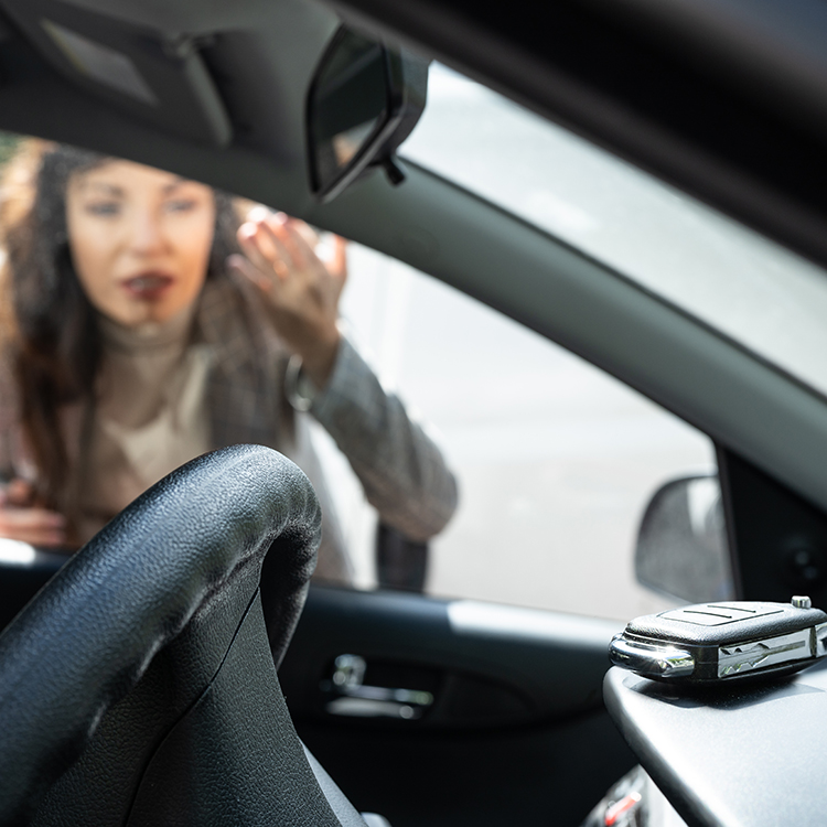 Woman looking at her key that she locked inside her car