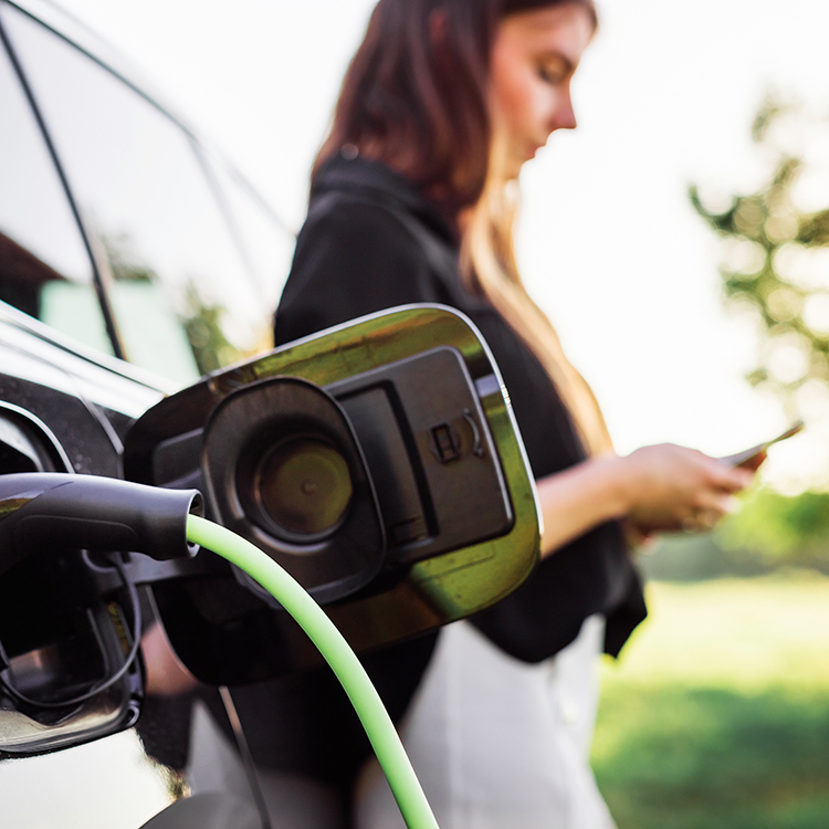 Woman on her phone while her EV charges