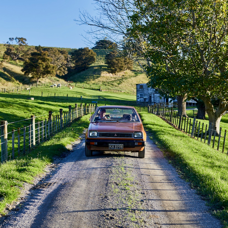 John Reisima and passenger Kiki the dog in his 1981 Mitsubishi Mirage.