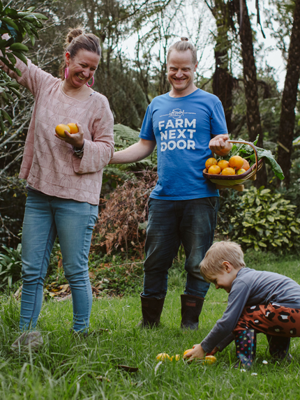 Kati and Carl Freeman with son, River, on their suburban farm in Taranaki. 