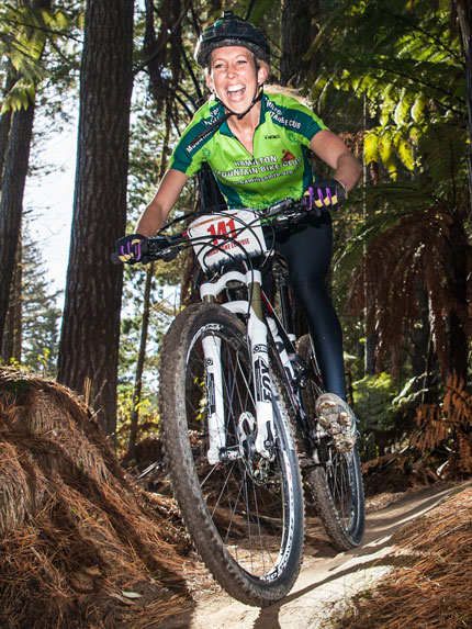 Woman riding a bicycle in the Whakarewarewa Forest, Rotorua