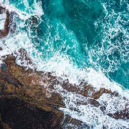 Aerial shot of waves against rocks