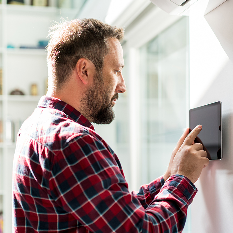 Man controlling house thermostat