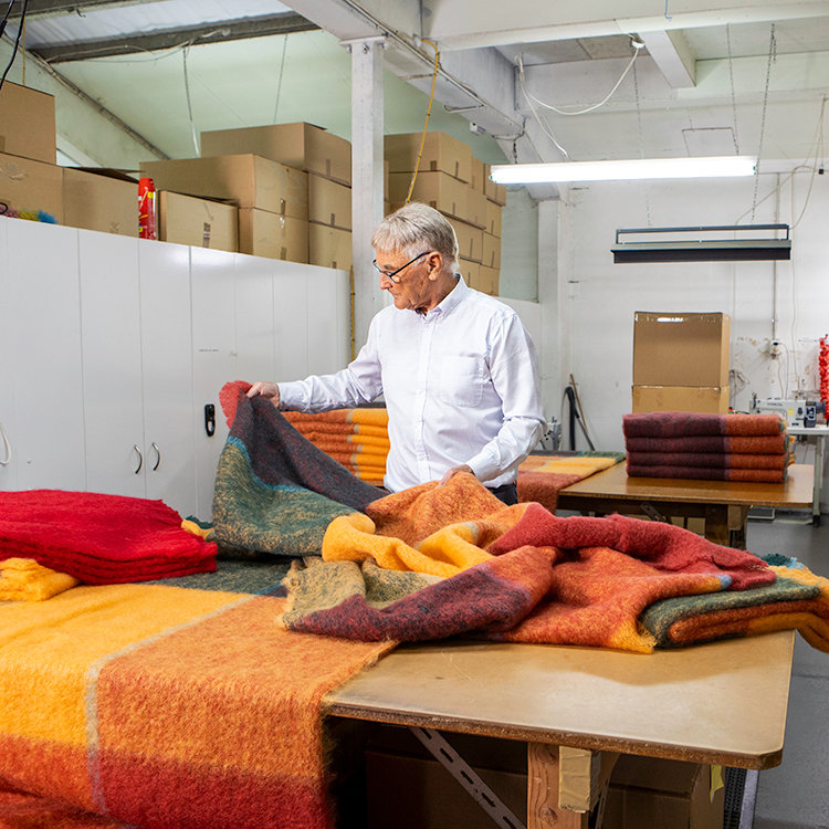 Lindsay Cairns inspects some of the beautiful textiles made at Masterweave. Photo by Nicola Edmonds.