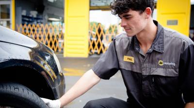 Male AA Motoring employee inspecting a tyre