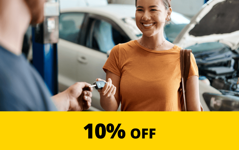 Young woman being handed her keys at a mechanic
