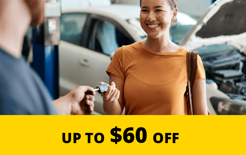 Young woman being handed her keys at a mechanic