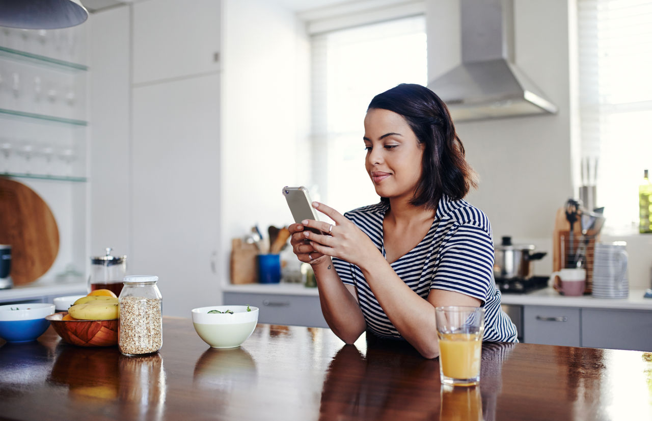Shot of an attractive young woman using her cellphone at home