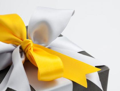 Gift box with a yellow and white bow around it