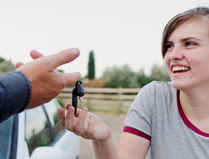Woman smiling while being given car keys