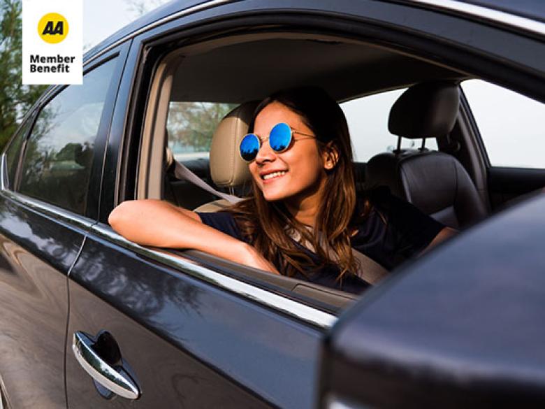 Woman with glasses smiling out a window