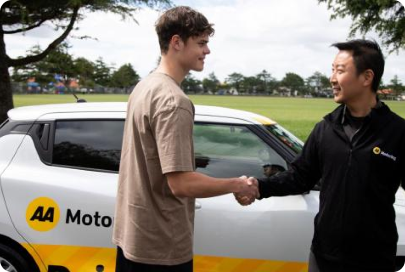 A young man shaking hands with an AA driving instructor